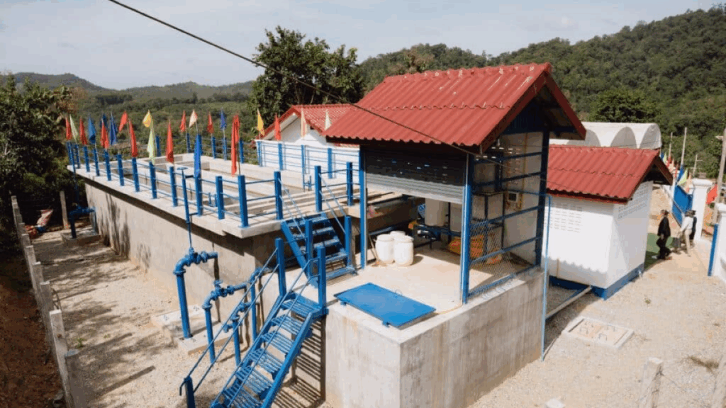 Infrastructures techniques de la nouvelle station de traitement d'eau potable à Luang Prabang, présentant des bâtiments aux toits rouges et des escaliers de maintenance bleus.